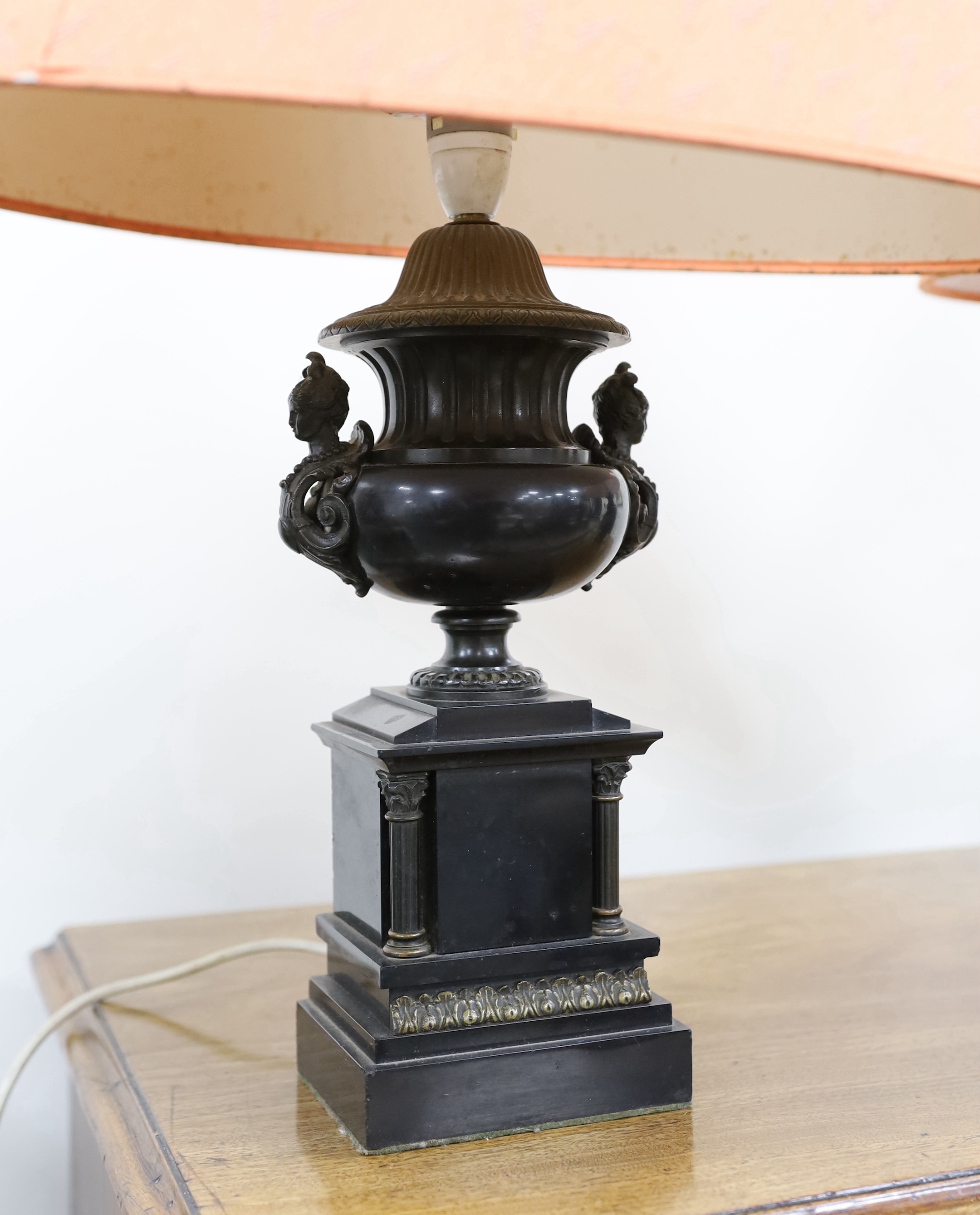 A pair of bronze and polished slate urns, converted to desk lamps (likely ex clock garniture), 34cm high excluding the fitting